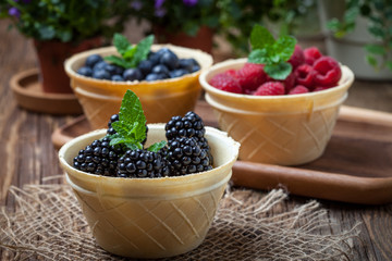 Blackberries, raspberries and blueberries in a waffle bowls.