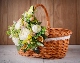 Fototapeta na wymiar Festive basket decorated with flowers on wooden background.