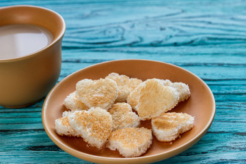 On a wooden background are the hearts with a cup of coffee. Valentine's day concept.