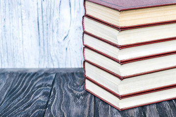 A stack of red books on a wooden table. concept of reading habits