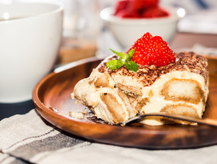 Homemade tiramisu cake decorated with strawberries Italian cuisine, Selective focus