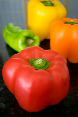 Several colorful peppers on black granite counter