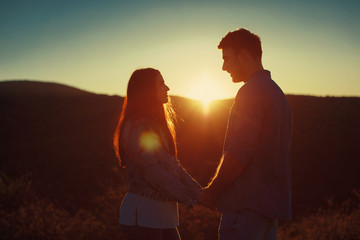 Young loving couple enjoys the sunset