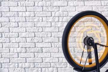 Spinning wheel of bicycle near brick wall