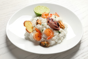 Plate with tasty seafood risotto on table