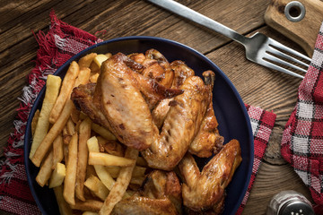 Baked chicken wings with french fries.