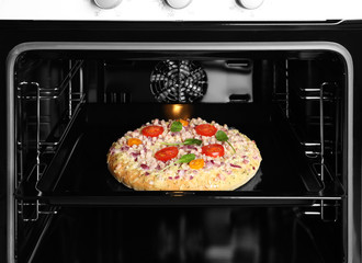 Tasty pizza on baking sheet in oven