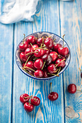 Fresh cherries in a blue bowl.