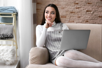 Young woman using laptop indoors