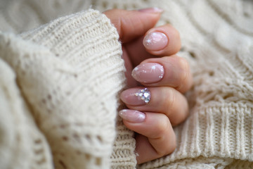 Nail Polish. Art Manicure. Modern style blue Nail Polish.Stylish pastel Color pink white Nails holding wool material sleeve blouse isolated white background wall. Classic wedding bride nails design