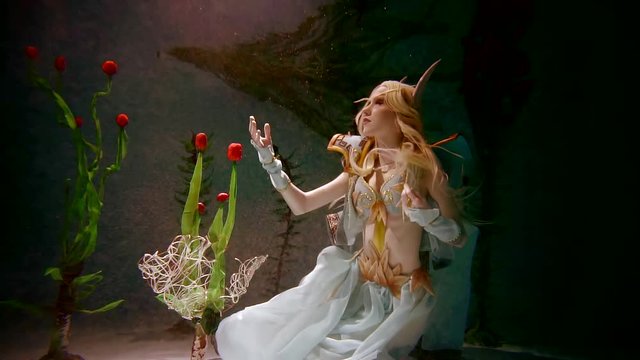Mysterious inhabitant of the underwater world elf girl. Touches to underwater plants