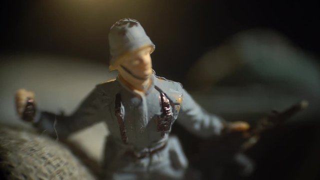 Toy soldier in gray uniform attacks