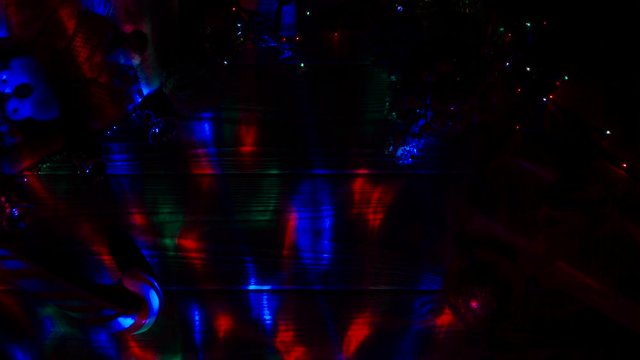 Dark room, garlands are burning, on the table lies a candy and New Year's toys. Top view