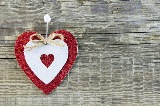 Designer heart hanging on wooden background