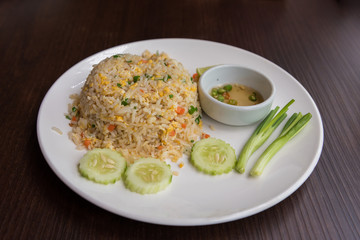Crab meat fried rice with vegetables in dish on wooden table