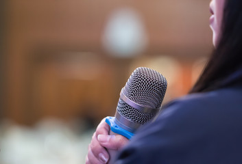 Smart Businesswoman speech or Speaking with microphone in Seminar hall, hand gesturing protesting or belief for explaining in conference hall. Speaker tedtalk is vocalized form of communication humans