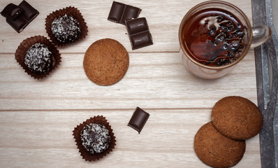 sweets and a cup of tea on a wooden background