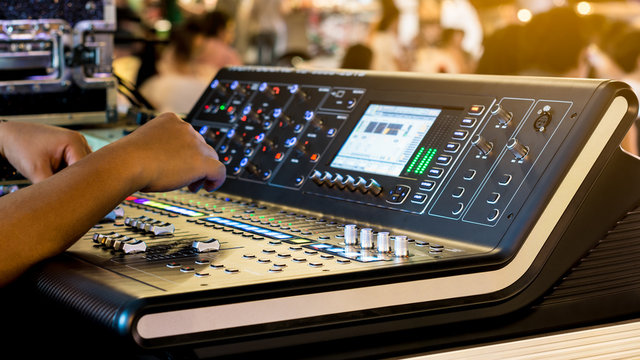 Sound technician control professional audio mixer in concert. Selective focus.