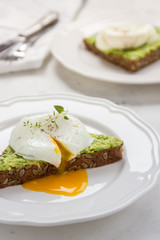 Sandwich with avocado and poached egg. Healthy breakfast