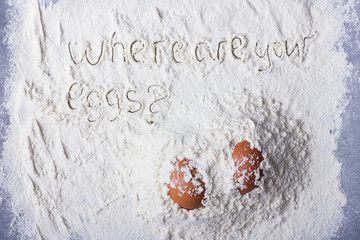 Fototapeta na wymiar Two eggs in piles of flour and the words where are your eggs