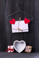 Red paper hearts on a clothes hanger. Dark wooden background. Copy space. St. Valentine's Day.