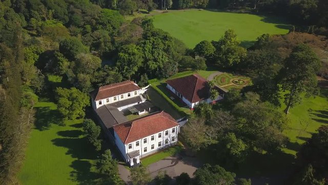 Aerial top view of beautiful building at green lawn at sunset drone footage