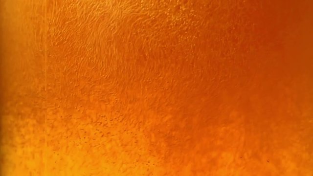 Bubbles and froth in the glass of light beer. Close-up.