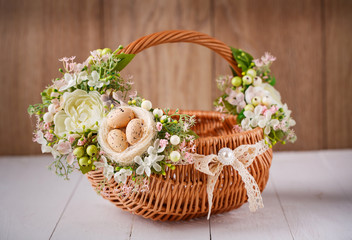 Fototapeta na wymiar basket with flowers to celebrate Easter on a wooden background