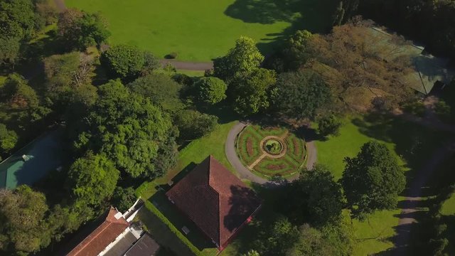 Aerial top view of beautiful building at green lawn at sunrise drone footage
