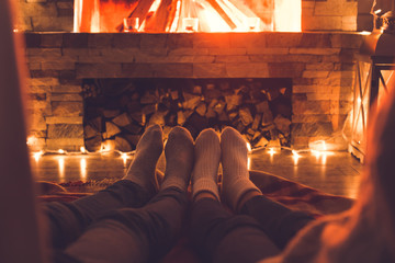 Young couple near the fireplace at home winter legs close-up