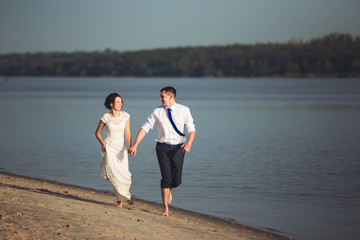 Sensual young happy couple celebrating their love on the beach and having fun. Toned image