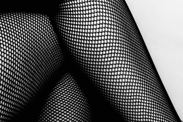 Black and white female legs in fishnet stockings
