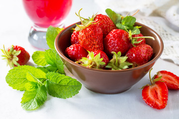 Freshly squeezed strawberry berry juice and fresh strawberry berries on a gray stone or slate background. The concept of nutrition for superfoods and health or detoxification. Copy space.