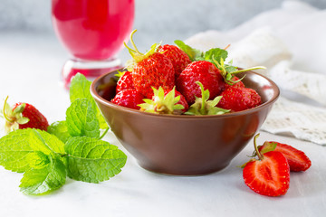 Freshly squeezed strawberry berry juice and fresh strawberry berries on a gray stone or slate background. The concept of nutrition for superfoods and health or detoxification. Copy space.