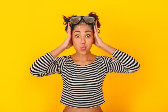 Young african woman isolated on yellow wall studio teen style holding head