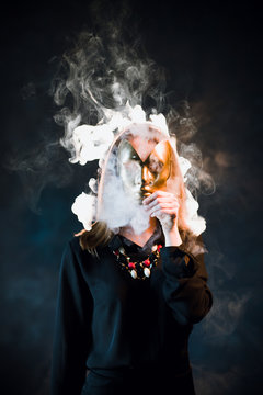 Woman covering her face with a mask surrounded by nicotine fumes. Danger of being passive smoker concept