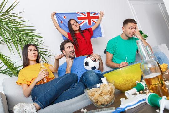 Group of friends sport fans watching match in colorful shirts concerned
