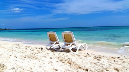 Fototapeta na wymiar Beach chairs isolated blue waters