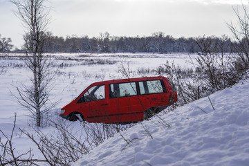 Car in ditch after winter accident. Vehicle loses control and drove off road at ice.