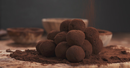sprinkling handmade truffles with cocoa powder