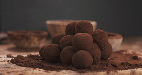 sprinkling handmade truffles with cocoa powder