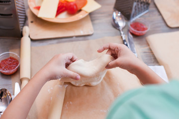 the process of cooking pizza, the child works with a pizza test, a children's culinary lesson