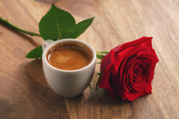fresh espresso with red rose flower on wood table