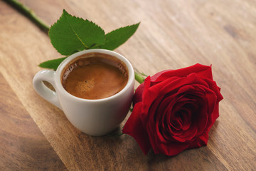fresh espresso with red rose flower on wood table