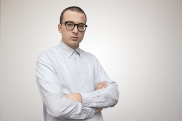 Portrait of young handsome man in blue shirt looking through his glasses. Doctor or businessman or professor style concept. Selective focus and shallow DOF