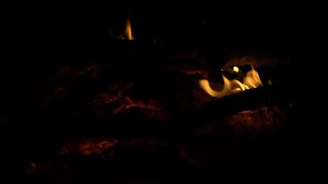 Yellow fire on hot coals at night, slow motion, full hd video clip