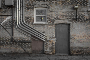 Brick wall with pipes and metal door