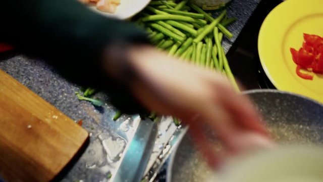 Layout of cooking ingredients on a kitchen counter, green beans, chicken, red peppers