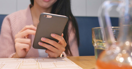 Woman using smart phone in restaurant