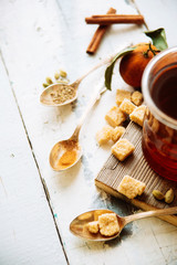 mulled wine in a mug and ingredients for making a drink on a white wooden background, top view